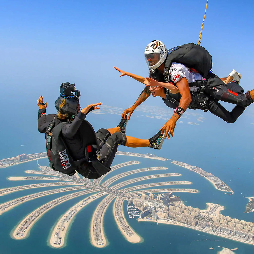 three people sky diving over palm jumeirah